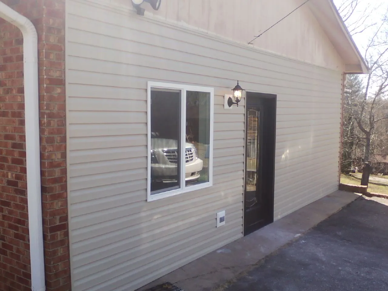 New vinyl siding and entry door on a room addition in Ennis