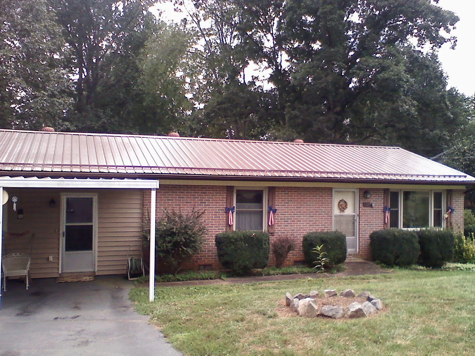 Bronze metal roof and carport on a brick ranch home — Roof Repair work by our crew in Ennis